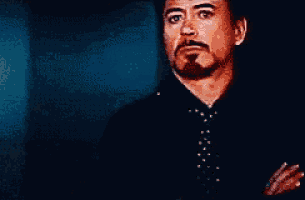 a man with a beard and mustache is wearing a black shirt and tie