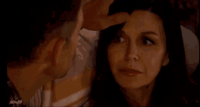 a man is kissing a woman 's forehead in a close up .