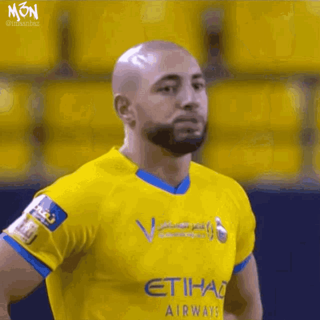 a man wearing a yellow etihad airways shirt
