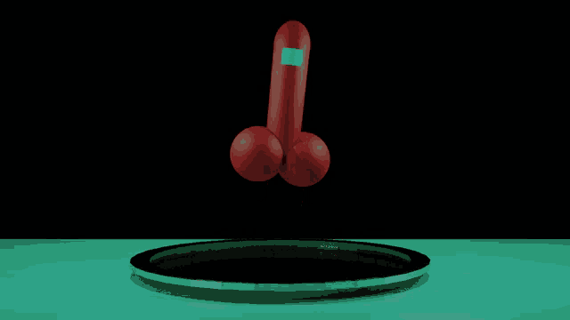 a red penis with a blue square on it is sitting on a green surface