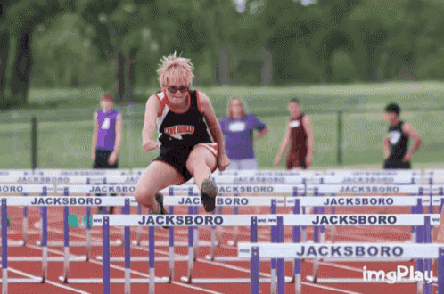 a person jumping over hurdles on a track that says jacksboro