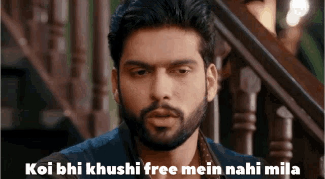 a man with a beard says koi bhi khushi free mein nahi mila in front of stairs
