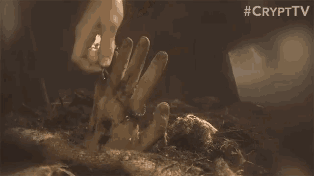a close up of a person 's hand in the dirt