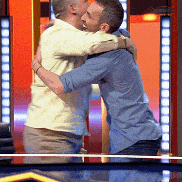 two men are hugging each other in front of a sign that says passive income