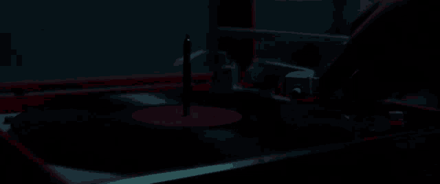 a person is playing a record on a turntable in a red light