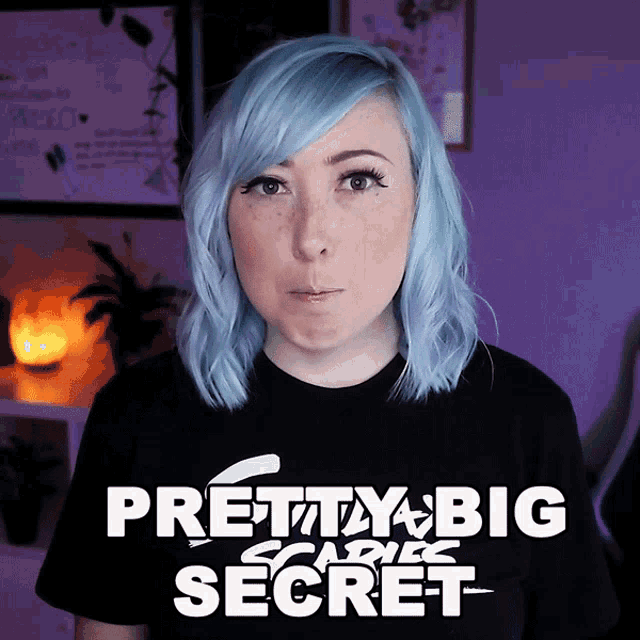 a woman with blue hair is wearing a black shirt that says pretty big scare secret