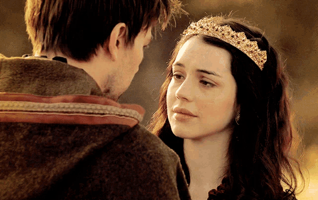 a woman wearing a tiara is looking at a man