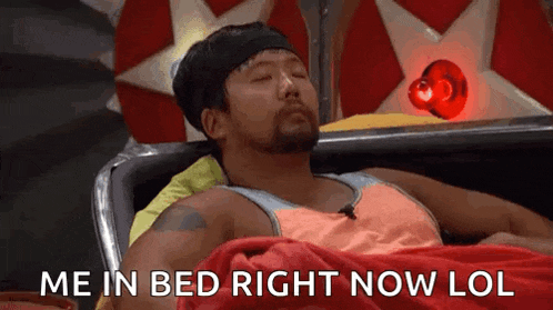 a man with a beard is laying in a bed with the words `` me in bed right now lol '' written on it .