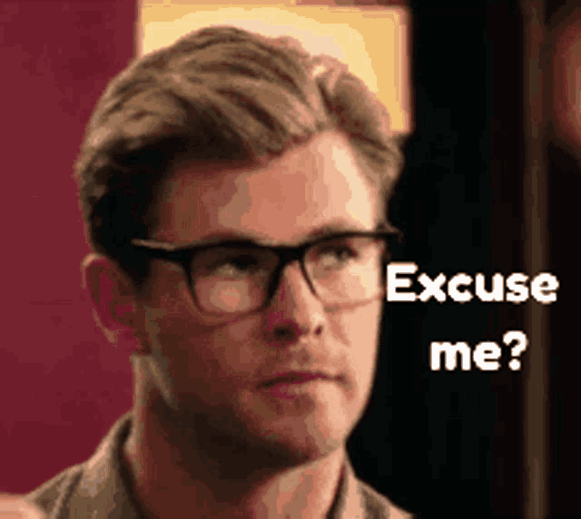 a man wearing glasses is looking at the camera and says excuse me ?