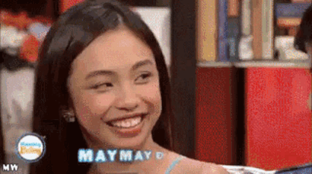 a girl with the name maymay on her neck smiles