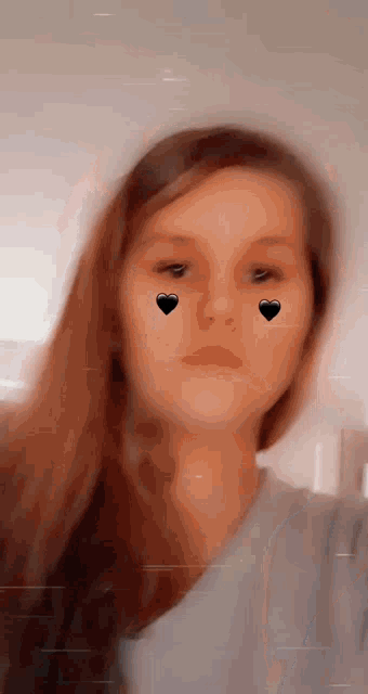 a close up of a girl 's face with hearts on her eyes .