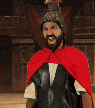 a man wearing a helmet and a red cape holds a sword