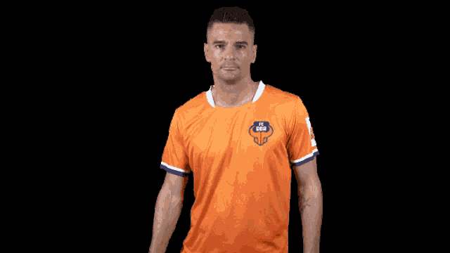 a man wearing an orange shirt that says ucl goa on it