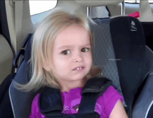 a little girl sitting in a car seat with faked humor written below her