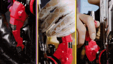 a close up of a person holding a red robot 's arm