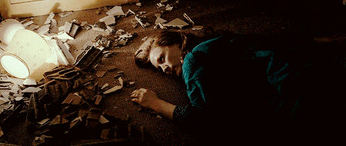 a woman is laying on the floor with broken glass on the floor