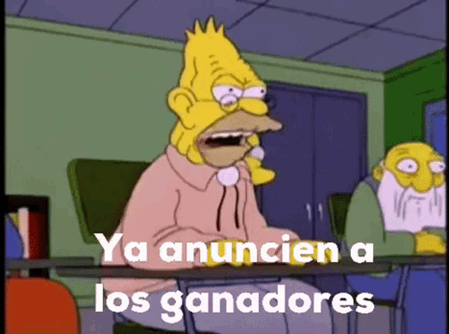 homer simpson is sitting at a desk with the words ya anuncien a los ganadores in front of him