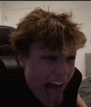a close up of a person 's face with their tongue hanging out .