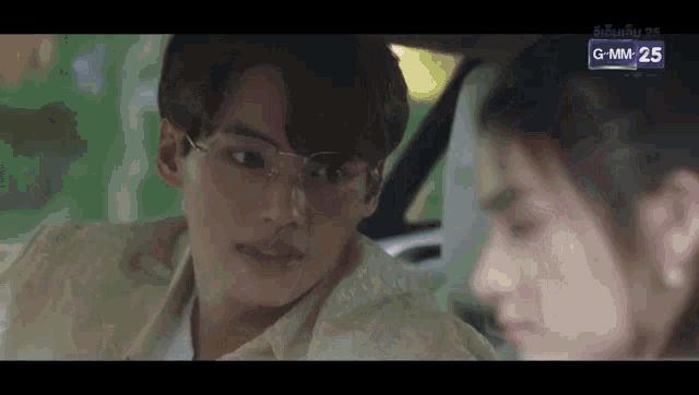 a man and a woman are sitting in a car . the man is wearing glasses .