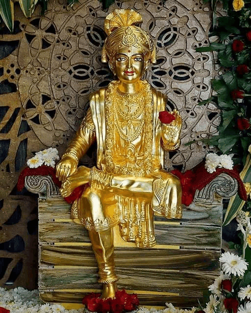 a gold statue of a man is sitting on a wooden box surrounded by flowers