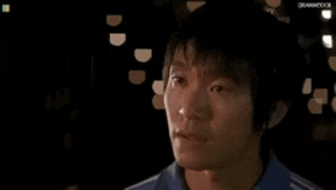 a close up of a man 's face in a dark room with lights behind him .
