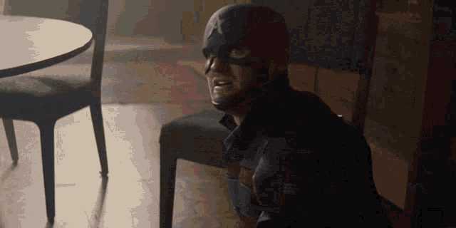 a man in a captain america costume sitting on a chair