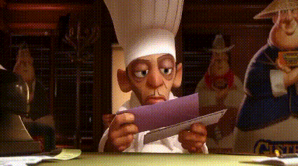 a man in a chef 's hat is looking at a piece of paper