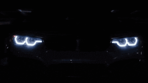 a close up of a car 's headlights that are lit up in the dark