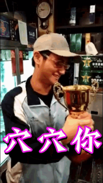 a man wearing a hat and glasses is holding a trophy with chinese writing on the bottom