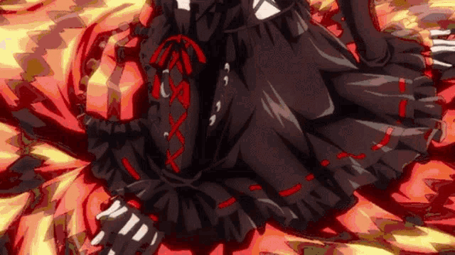 a woman in a black dress with red ribbons is laying on a bed