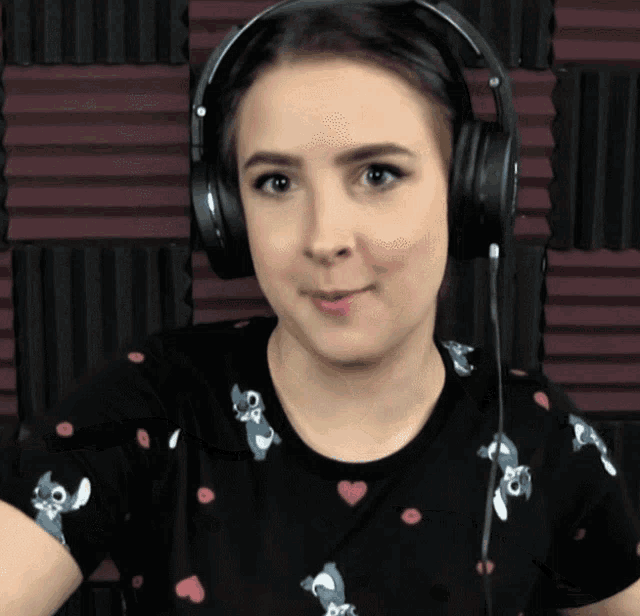 a woman wearing a black shirt with stitch on it and headphones
