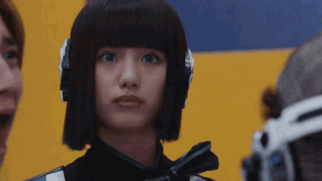 a woman wearing headphones looks at the camera with a surprised expression