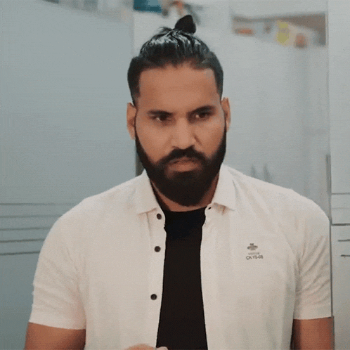 a man with a beard is wearing a white shirt that says ok 15-08 on it
