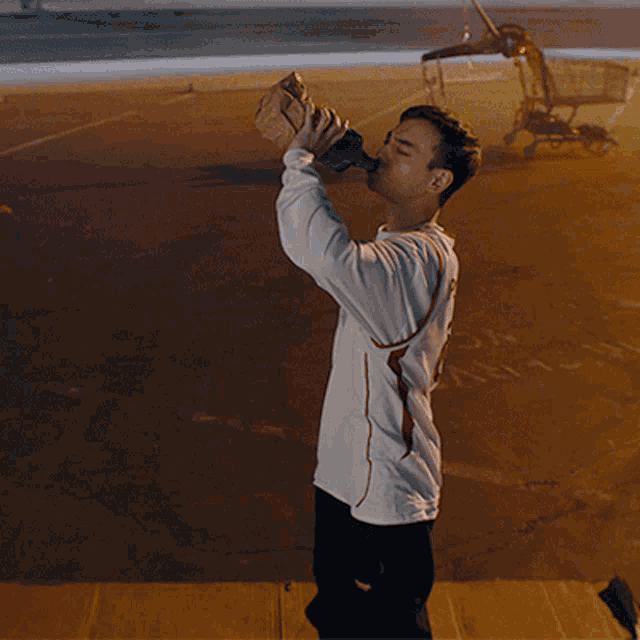 a man is drinking from a bottle with the number 2 on the back