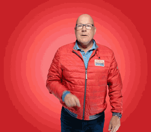 a man wearing a red jacket has a name tag that says ' positief ' on it