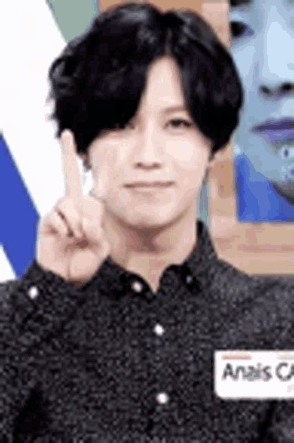a man is giving a peace sign with his finger .