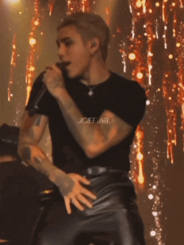 a man is singing into a microphone with the name joiif.521 on the bottom