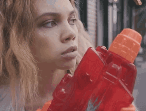 a woman is holding a red water gun with a dragon on the side