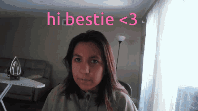 a woman sitting in front of a sign that says hi bestie