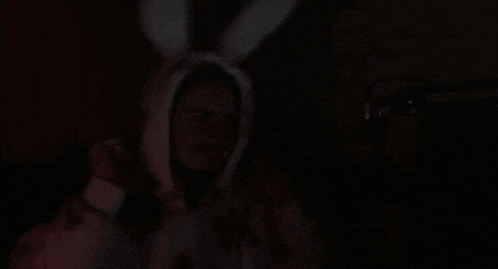 a man in a bunny costume is standing in the dark .