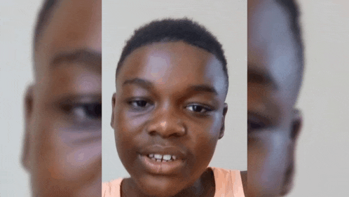 a close up of a young boy 's face with his mouth open .