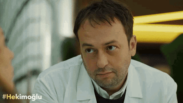a man in a white lab coat with the hashtag #hekimoglu on the bottom right