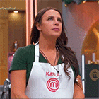 a woman wearing a white apron with the letter m on it .