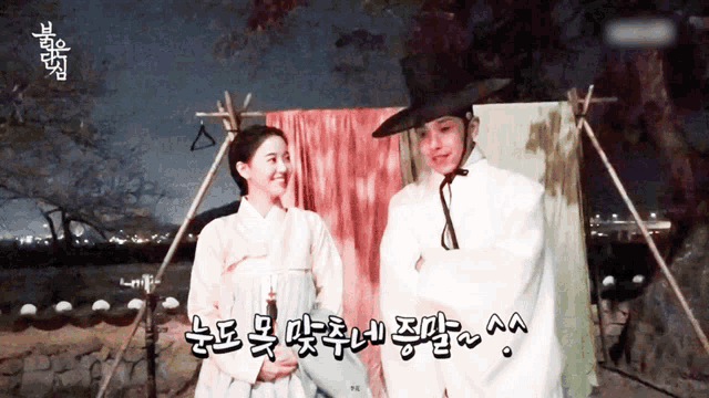a man and a woman are standing next to each other with korean writing on the bottom