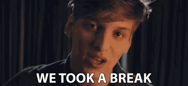 a young man is smiling with the words " we took a break " behind him