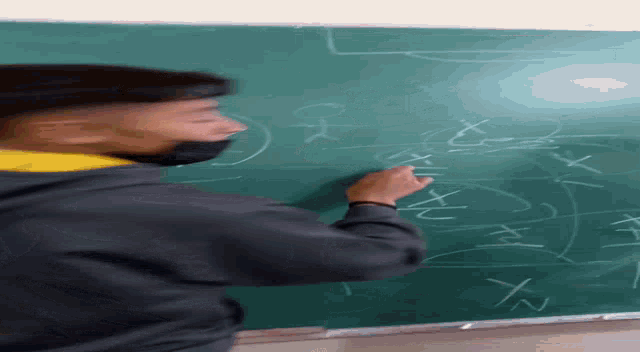 a man is writing on a chalkboard with x and y on it