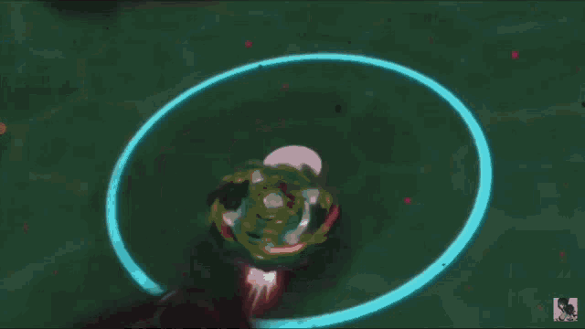 a spinning top is surrounded by a blue circle with the letter k on it .