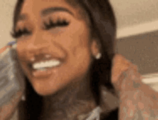 a close up of a woman smiling and talking on a cell phone .