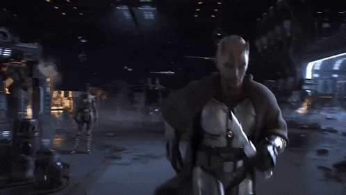 a man is holding a green lightsaber and the words let 's go are behind him
