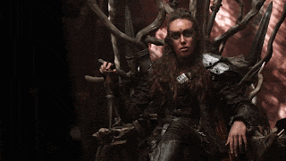 a woman is sitting on a throne holding a sword